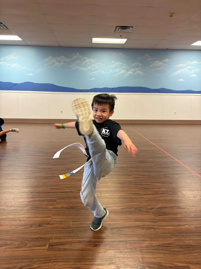 A Karate Zoo student practices a high kick during class