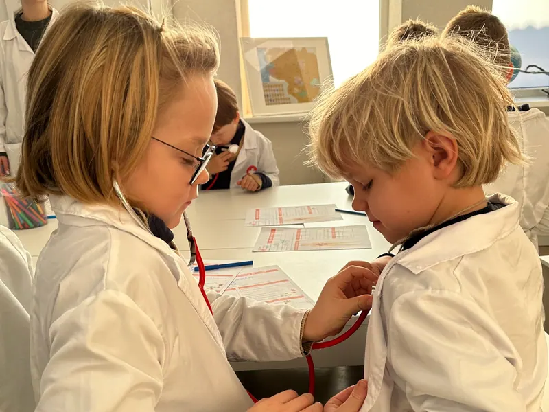 Children use a stethoscope together during a medical lesson