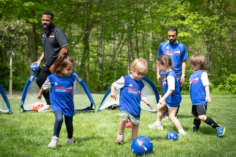 Young players practice outside with two coaches