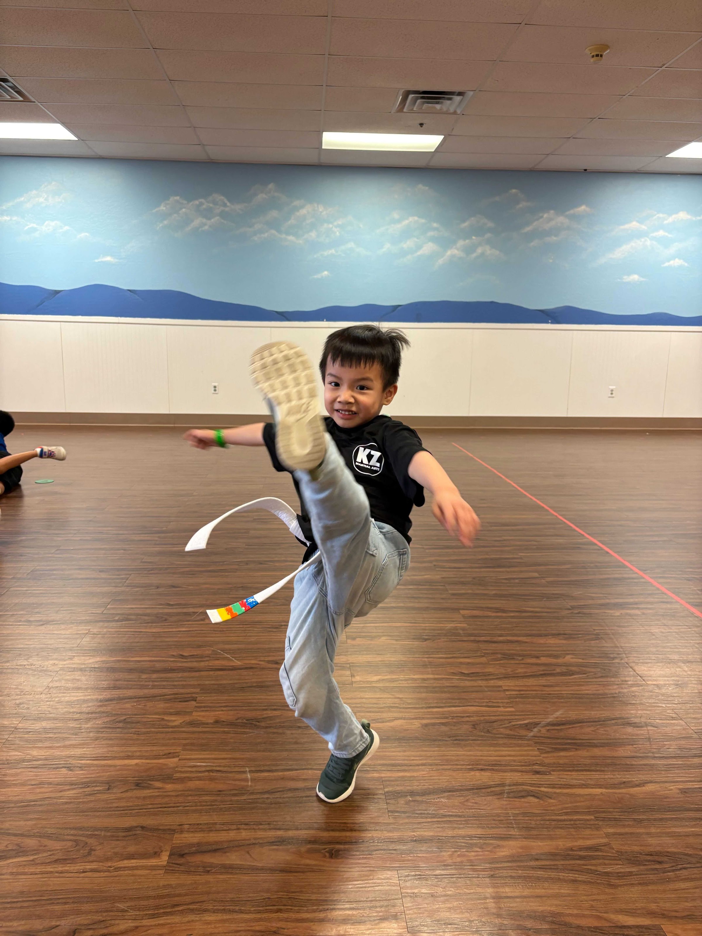 A Karate Zoo student practices a high kick during class