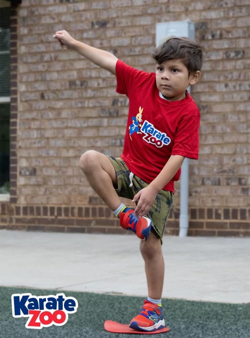 A young Karate Zoo student balances during a martial arts activity