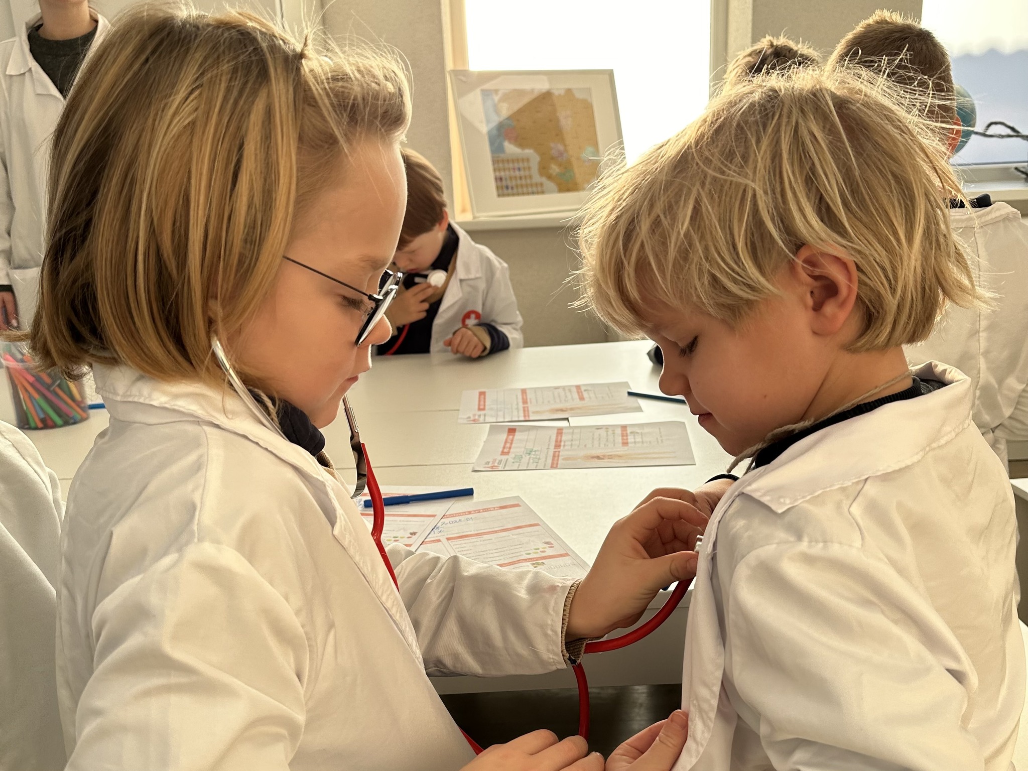 Children use a stethoscope together during a medical lesson