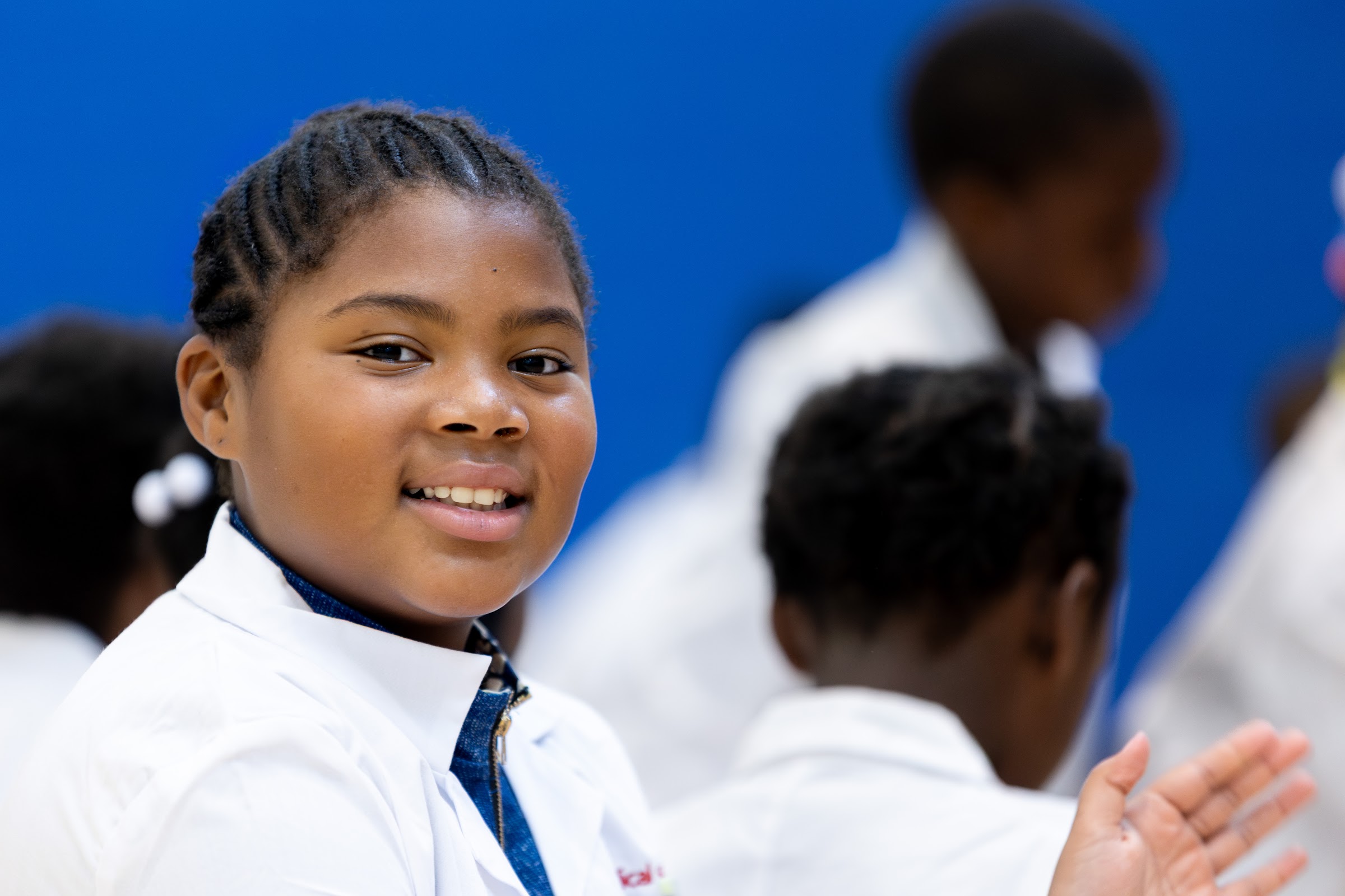 A Little Medical School student smiles in a lab coat