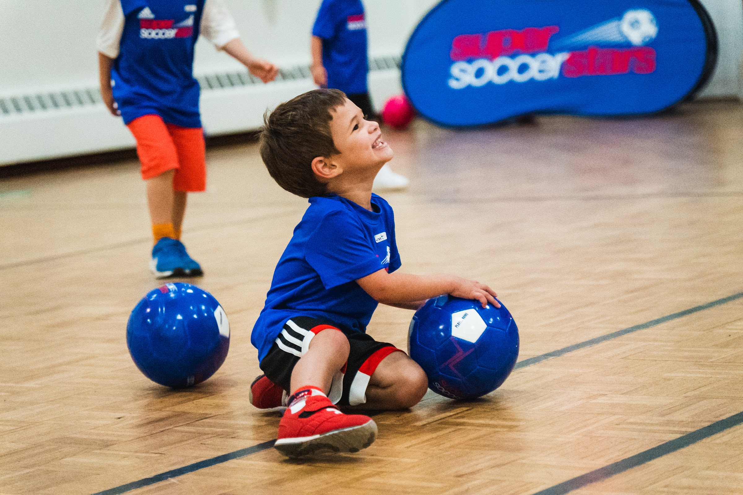 A young player smiles during an indoor neighborhood class