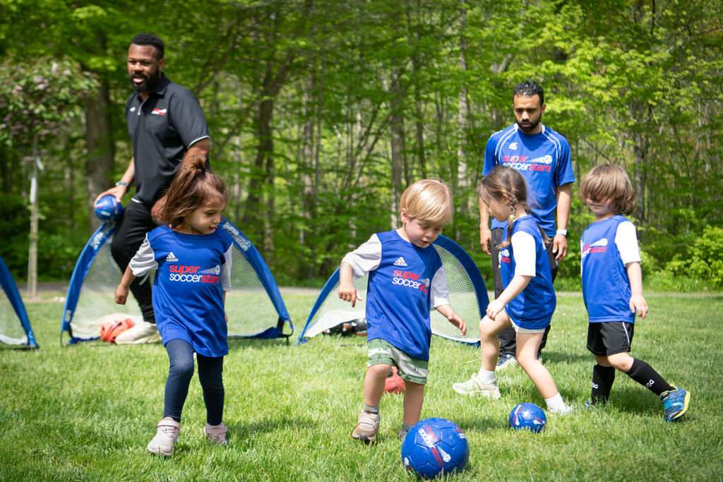 Young players practice outside with two coaches